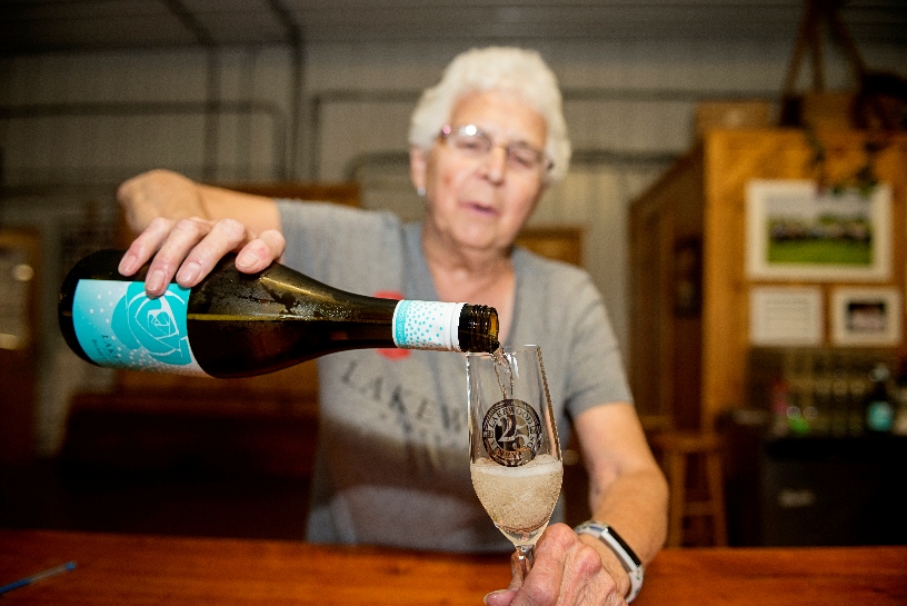 woman pouring glass of Bubbly Candeo